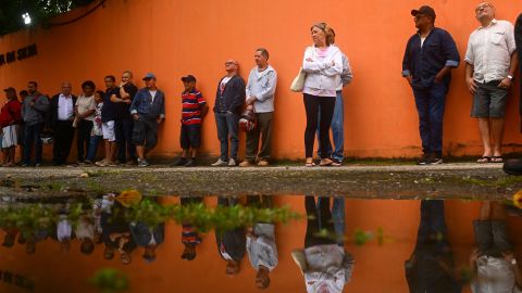 People queue to vote just outside Rocinha favela in Rio de Janeiro.