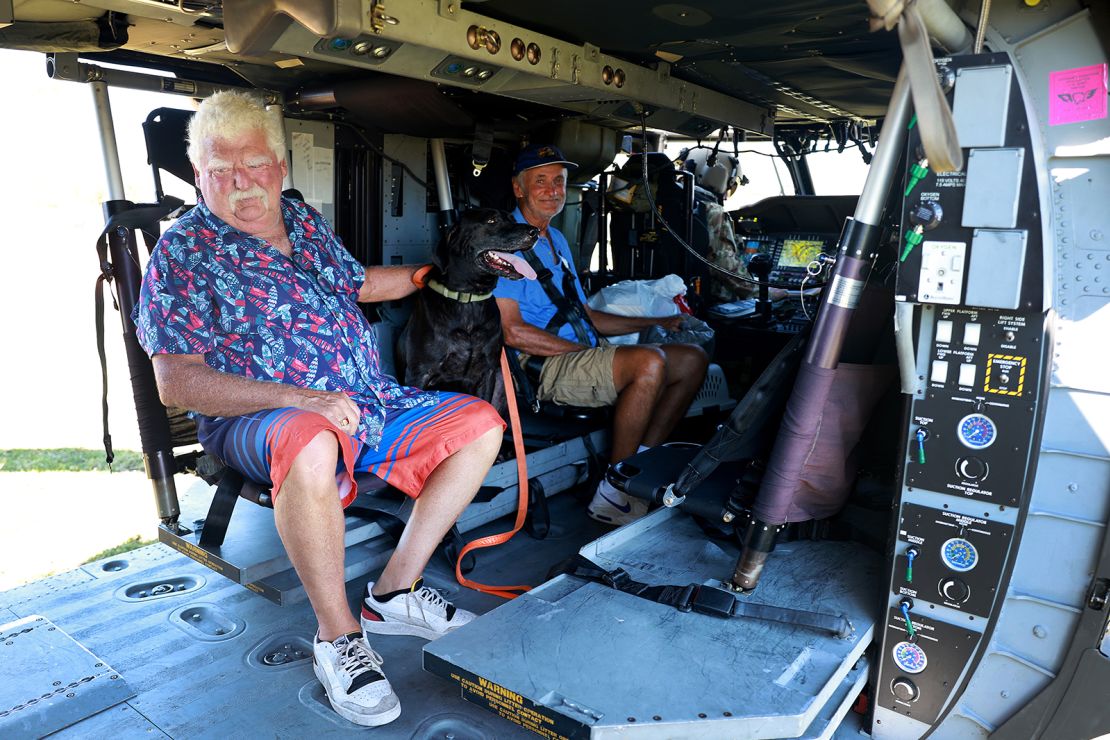 A man along with his dog prepares to be evacuated in a Florida Army National Guard helicopter in Pine Island, Florida.