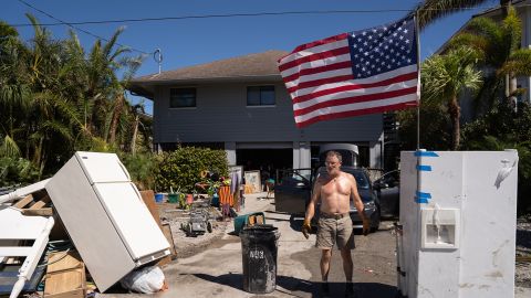 Un homme se tient devant une maison endommagée par une onde de tempête à la suite de l'ouragan Ian à Naples, en Floride.