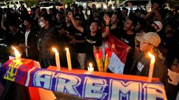 Soccer fans chant slogans during a candle light vigil for Arema FC Supporters who became victims of Saturday's soccer riots, outside the Youth and Sports Ministry in Jakarta, Indonesia, Sunday, Oct. 2, 2022.