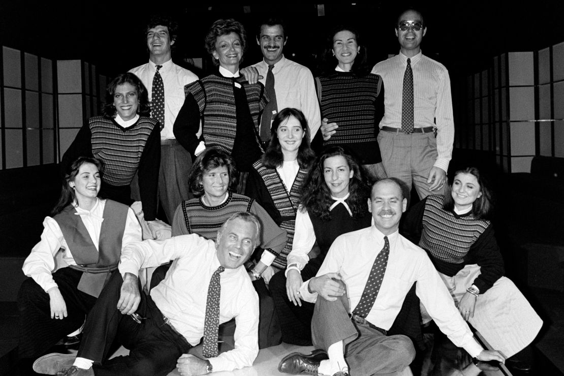 Giorgio Armani (front left) and Sergio Galeotti (front right) pose for a photo with staff members dressed in Armani designs.