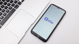 In this photo illustration a Zelle logo seen displayed on a smartphone screen on a desk next to a Macbook in Athens, Greece on September 29, 2022. (Photo Illustration by Nikolas Kokovlis/NurPhoto via Getty Images)
