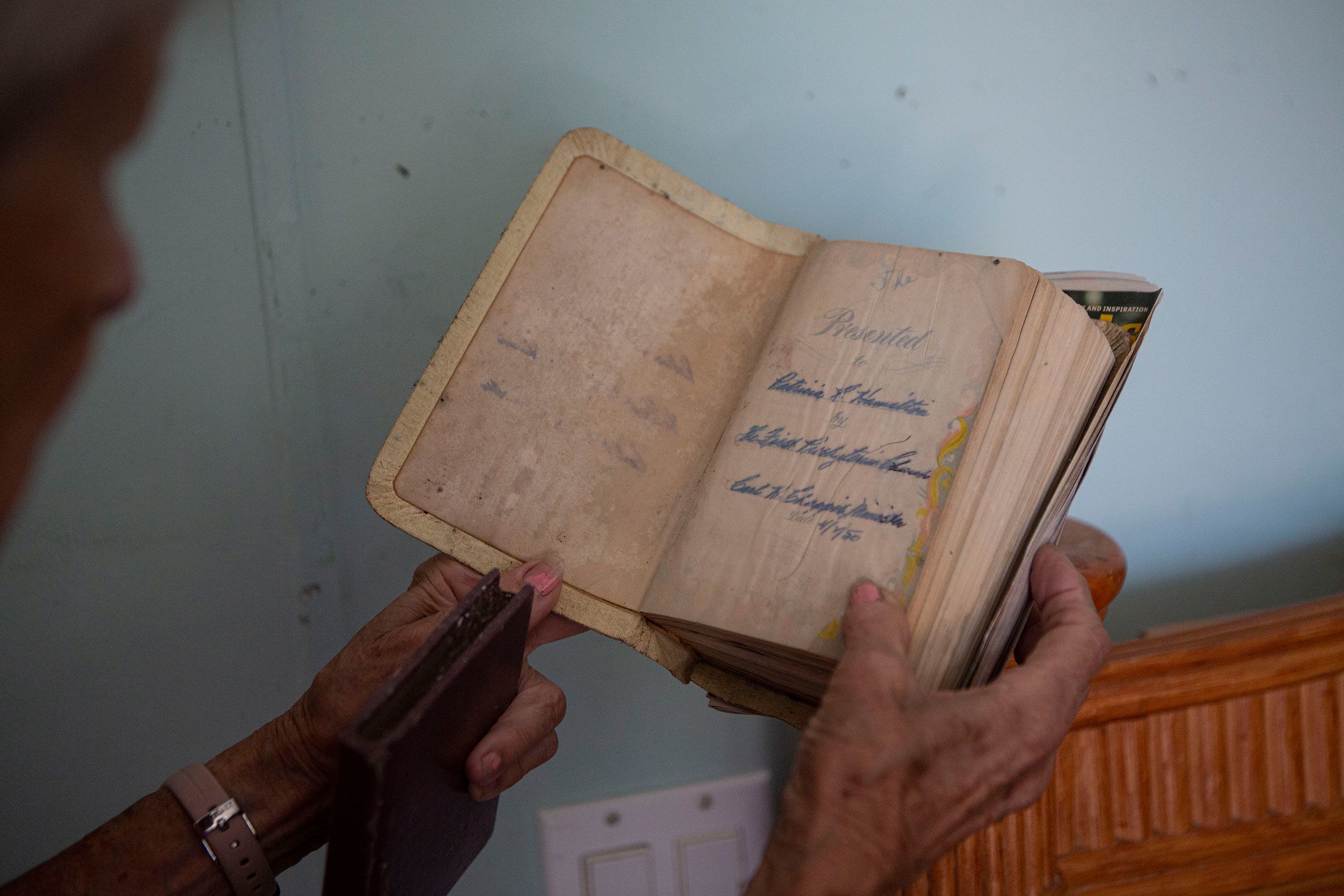 Pat Pickett tries to salvage a Bible inside her mobile home, which was damaged by Hurricane Ian floodwaters on Florida's San Carlos Island.