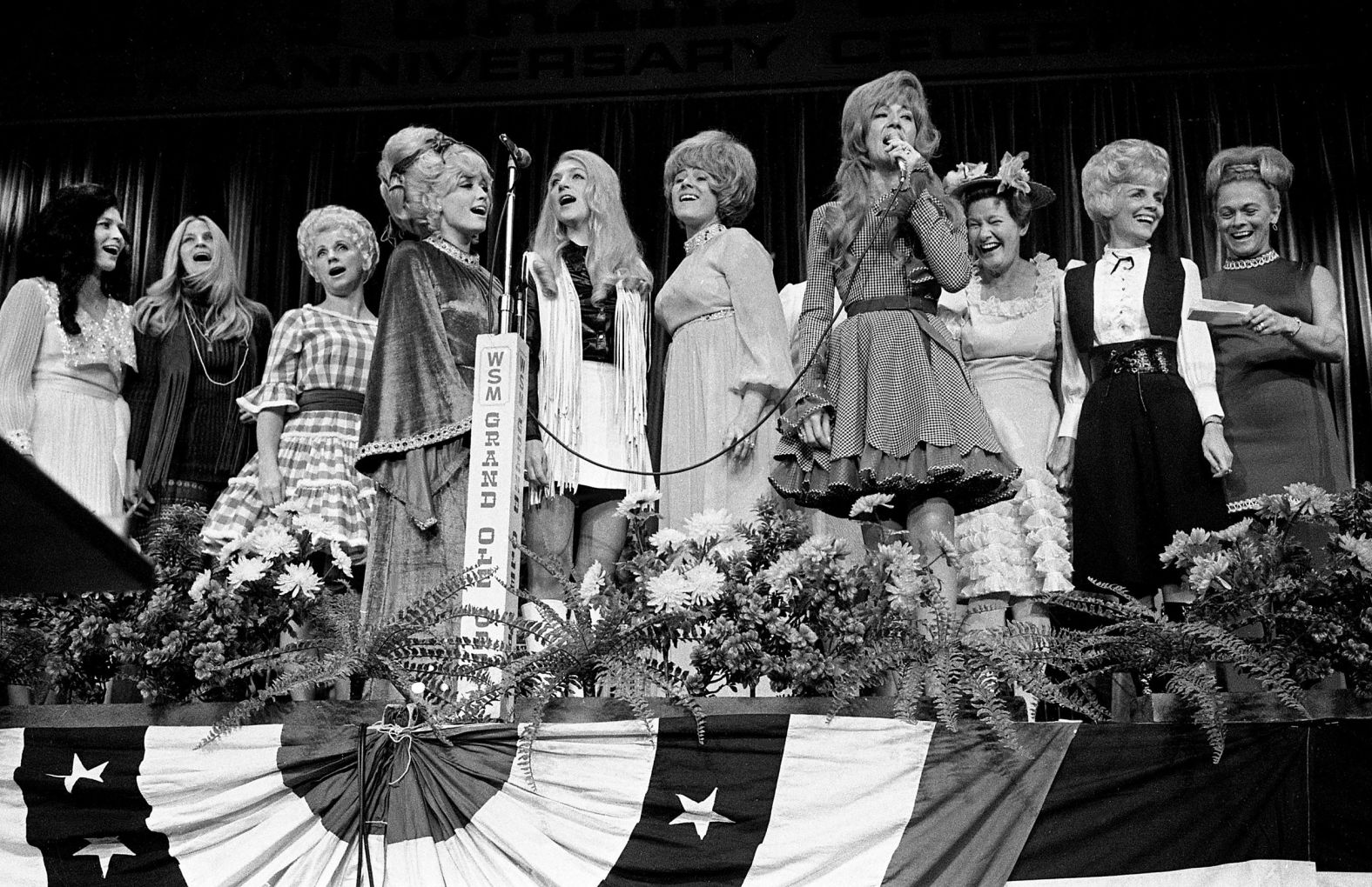 Lynn, left, joins fellow female country singers on stage as Dottie West, fourth from right, sings "Born To Be A Country Girl" at the Nashville Municipal Auditorium in 1970.