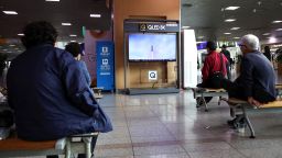 People watch a TV broadcasting a news report on North Korea firing a ballistic missile over Japan, at a railway station in Seoul, South Korea, October 4, 2022.