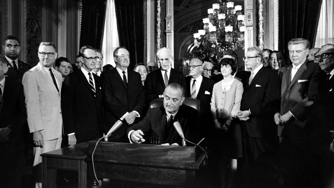 President Lyndon Johnson signs the Voting Rights Act of 1965 in a ceremony in the President's Room near the Senate chambers.
