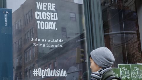 A woman walks past a closed REI store in New York on Black Friday, 2016.