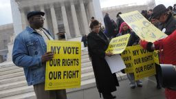 Activists distribute pro-voting rights placards outside of the US Supreme Court on February 27, 2013 in Washington, DC as the Court prepares to hear Shelby County vs Holder.