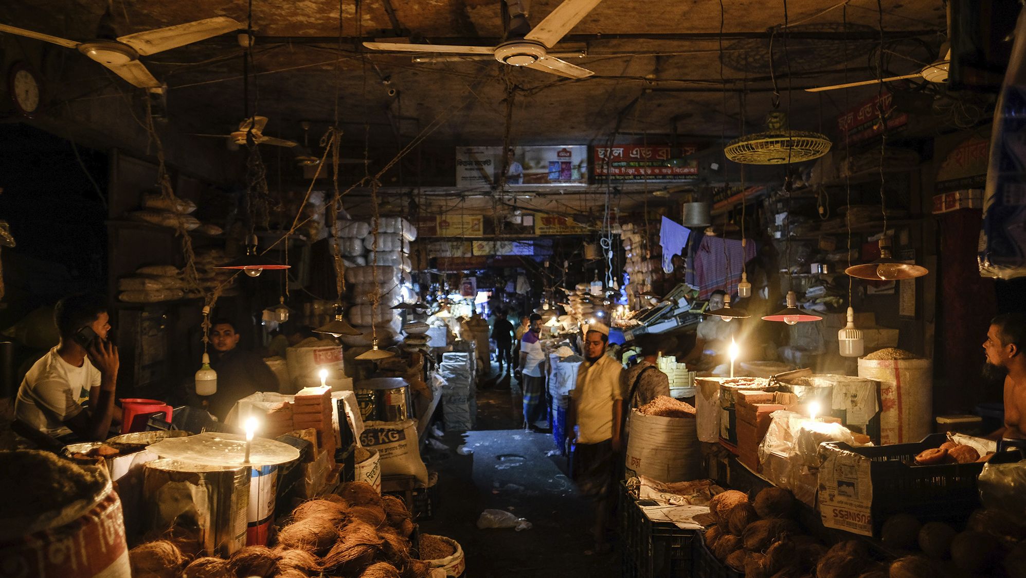 Vendors light candles at a market in Dhaka after a failure in Bangladesh's national power grid plunged much of the country into a blackout on October 4, 2022. 