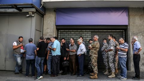 Lebanese depositors line up outside a fortified local bank in Beirut.