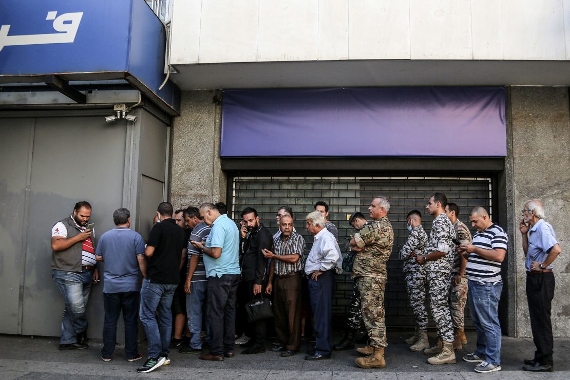 Lebanese depositors line up outside a fortified local bank in Beirut. 