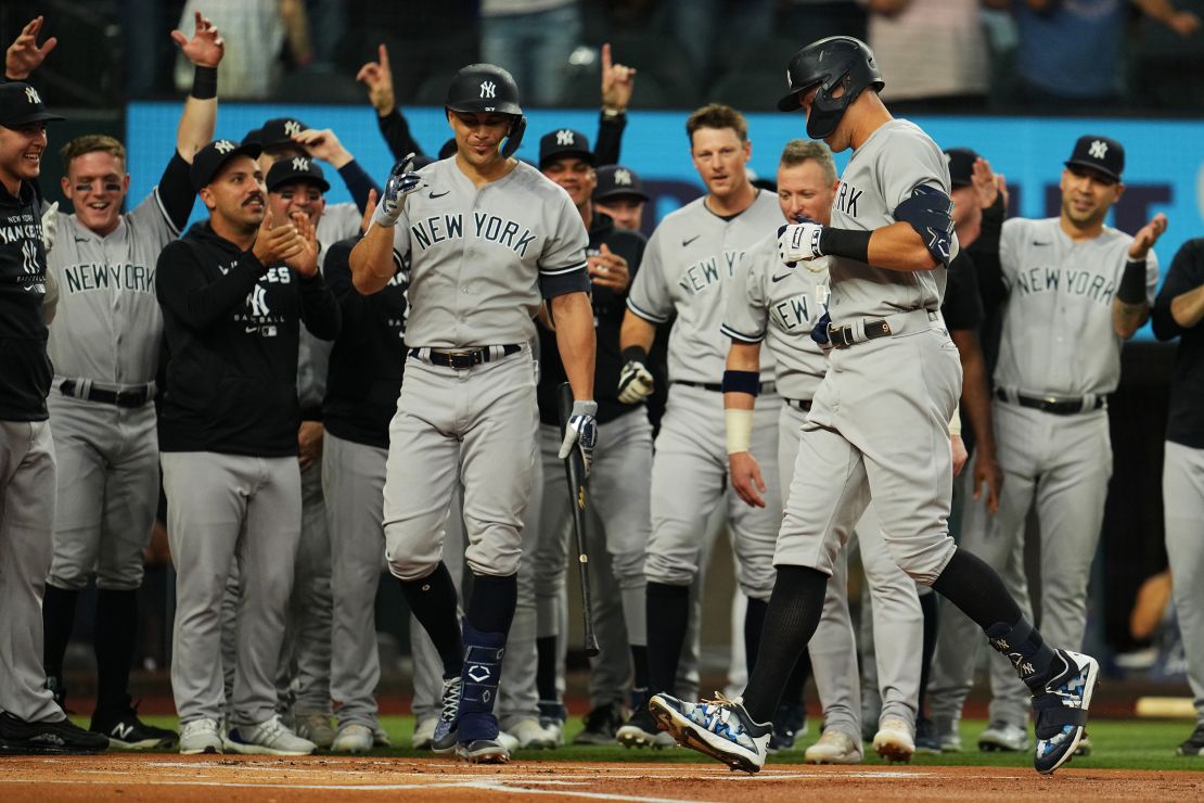 Aaron Judge celebrates with his  teammates at home plate after hitting his 62nd home run.