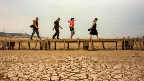 Tourists walk on an ancient bridge which emerged from dried Poyang Lake on September 21, 2022 in Jiujiang, Jiangxi province, China. 