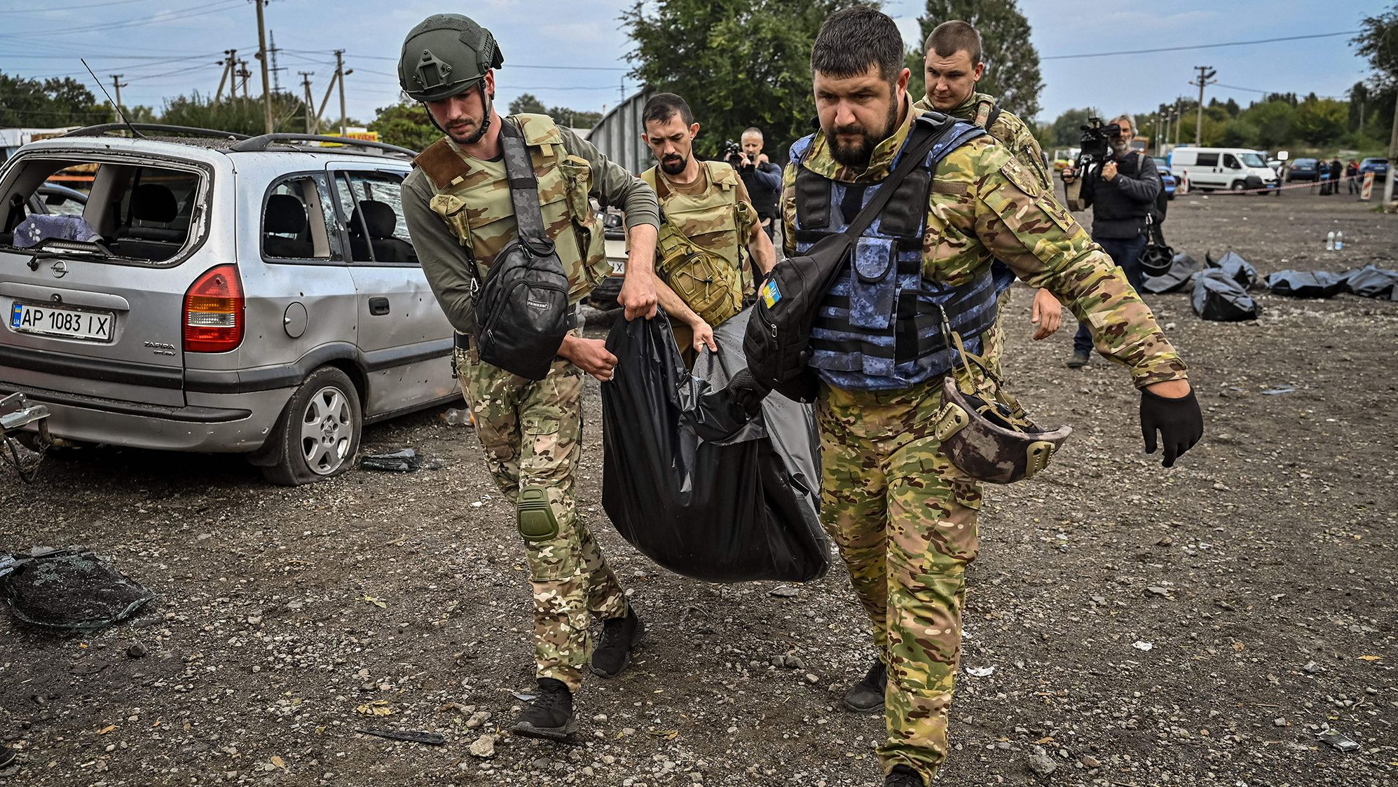 Ukrainian servicemen carry a body bag at the site of a missile <a href="https://edition.cnn.com/europe/live-news/russia-ukraine-war-news-09-30-22/h_7b936e41381bad5f5e4f54e10972f15a" target="_blank">strike on a convoy of civilian cars</a> that killed at least 30 people near Zaporizhzhia, Ukraine, on September 30.