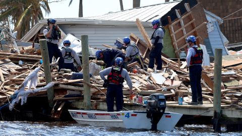 Members of the Miami-Dade Task Force 1 Search and Rescue team look Tuesday through debris for victims in Matlacha, Florida.