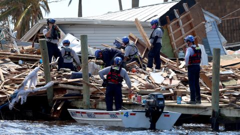 Members of the Miami-Dade Task Force 1 Search and Rescue team look Tuesday through debris for victims in Matlacha, Florida. 