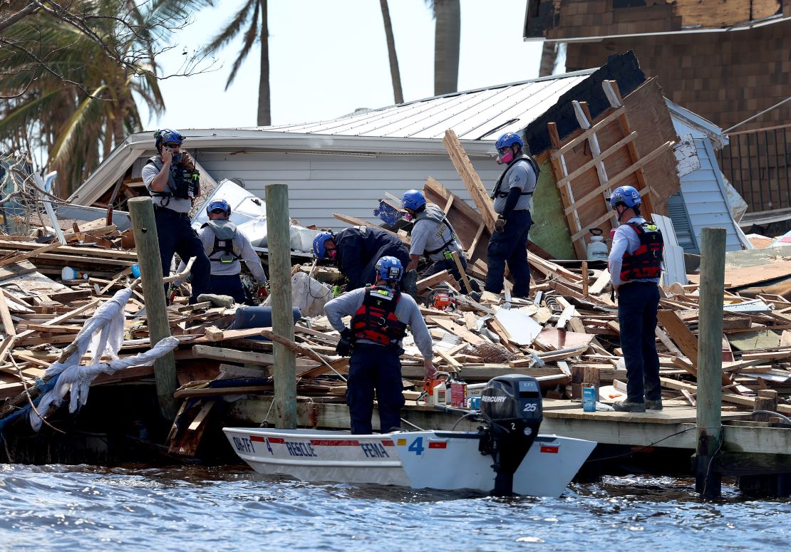 Members of the Miami-Dade Task Force 1 Search and Rescue team look Tuesday through debris for victims in Matlacha, Florida. 