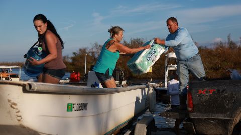 People load supplies onto a boat in Matlacha, Florida, to be taken to Sanibel Island Tuesday.