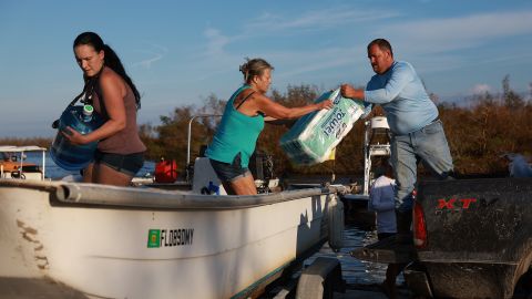 People load supplies Tuesday onto a boat in Matlacha, Florida, to be taken to Sanibel Island.