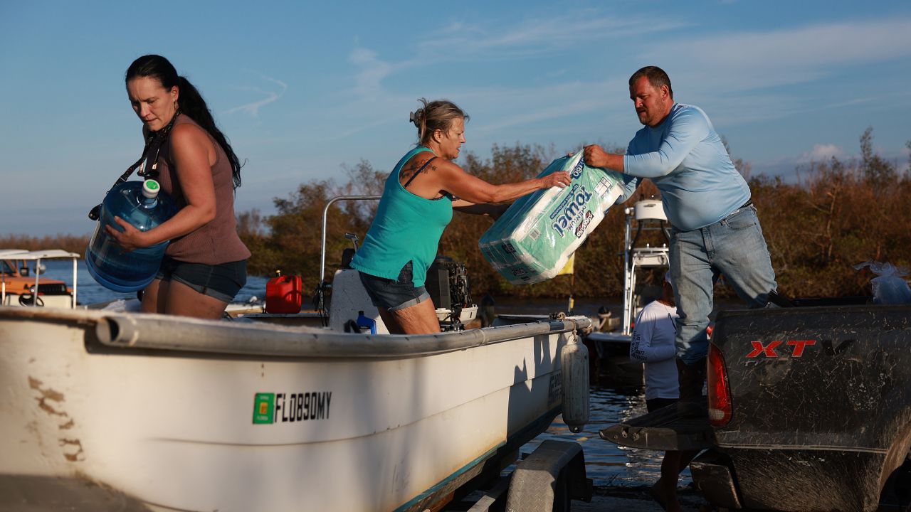 People load supplies Tuesday onto a boat in Matlacha, Florida, to be taken to Sanibel Island.