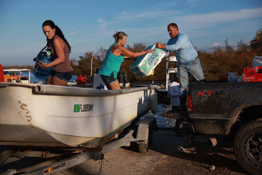 People load supplies Tuesday onto a boat in Matlacha, Florida, to be taken to Sanibel Island.
