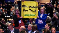 People hold up a sign in protest during British Prime Minister Liz Truss's speech, during Britain's Conservative Party's annual conference in Birmingham, Britain, October 5, 2022. REUTERS/Toby Melville