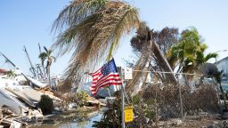 An American flag is seen flying in front of damage from Hurricane Ian in San Carlos Island, Fort Myers Beach, Florida on Tuesday, October 4. 