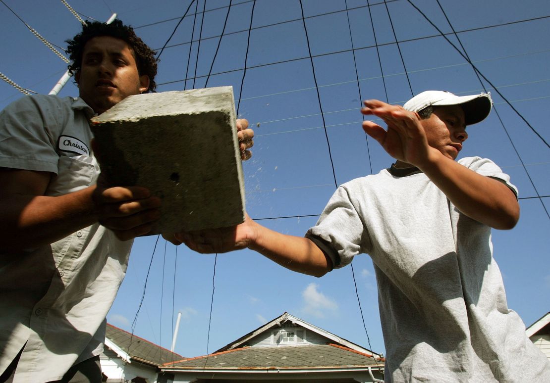This file photo from April 2006 shows immigrant workers performing "house leveling" work on a New Orleans home damaged by Huricane Katrina. 