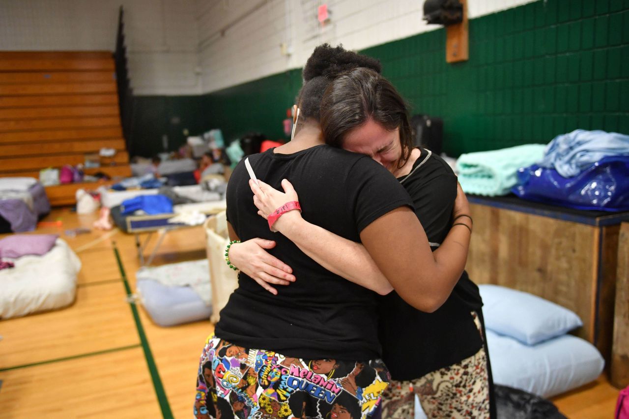 Stephanie Fopiano, right, gets a hug from Kenya Taylor, both from North Port, as she gets emotional about her situation at the Venice High School hurricane shelter in Venice, Florida, on Monday, October 3.