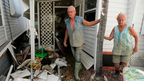 Snowbirds Bruce and Kathy Hickey, both 70, stand outside their damaged winter home in a mobile home park on San Carlos Island.