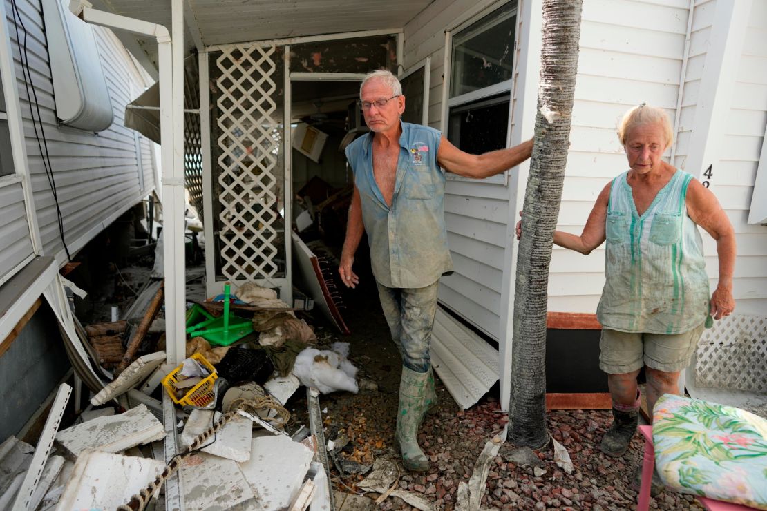 Snowbirds Bruce and Kathy Hickey, both 70, stand outside their damaged winter home in a mobile home park on San Carlos Island.