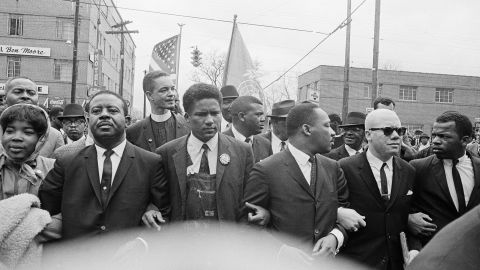 Dr. Martin Luther King, Jr. locks arms with his aides, including John Lewis, as he leads a march of several thousands to the court house in Montgomery, Ala., March 17, 1965.  