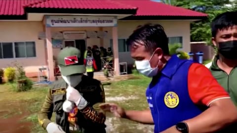 Officials and authorities guard the gate of daycare centre as people wait, after a mass shooting, in Uthai Sawan, Nong Bua Lamphu Province, Thailand in thisÊscreengrabÊtaken from video October 6, 2022. TPBS/ReutersÊTVÊvia REUTERS  THAILAND OUT. NO COMMERCIAL OR EDITORIAL SALES IN THAILAND. MANDATORY CREDIT. THIS IMAGE HAS BEEN SUPPLIED BY A THIRD PARTY. NO RESALES. NO ARCHIVES