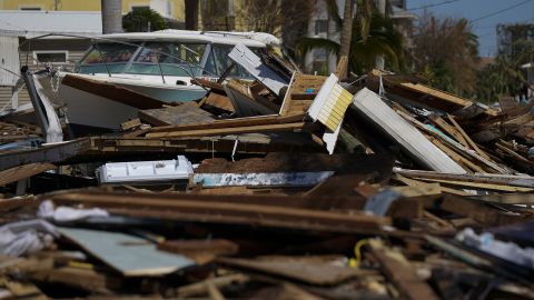A powerboat lies atop a pile of debris two days after the passage of Hurricane Ian, in Fort Myers, Florida. 