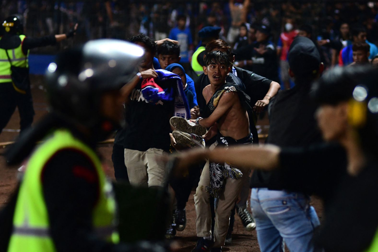 People carry an injured man after <a href="https://www.cnn.com/2022/10/01/asia/indonesia-soccer-stadium-stampede-persebaya-surabaya-arema-fc-intl-hnk" target="_blank">chaos and violence erupted</a> during a soccer match between Arema FC and Persebaya Surabaya on Saturday, October 1, at the Kanjuruhan Stadium in Malang, Indonesia. At least 125 people were killed, according to Indonesia's National Police Chief, in what is one of the world's deadliest stadium disasters of all time.