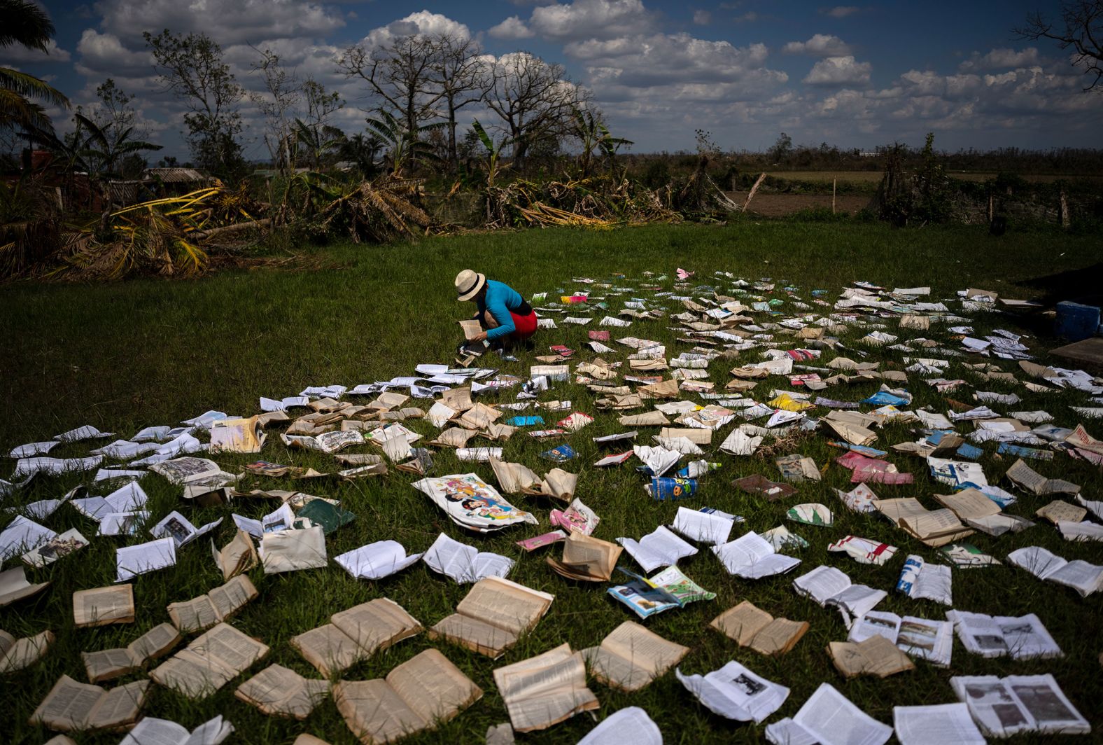A teacher dries out books on Wednesday, October 5, at a school that was heavily damaged by Hurricane Ian in La Coloma, Cuba.