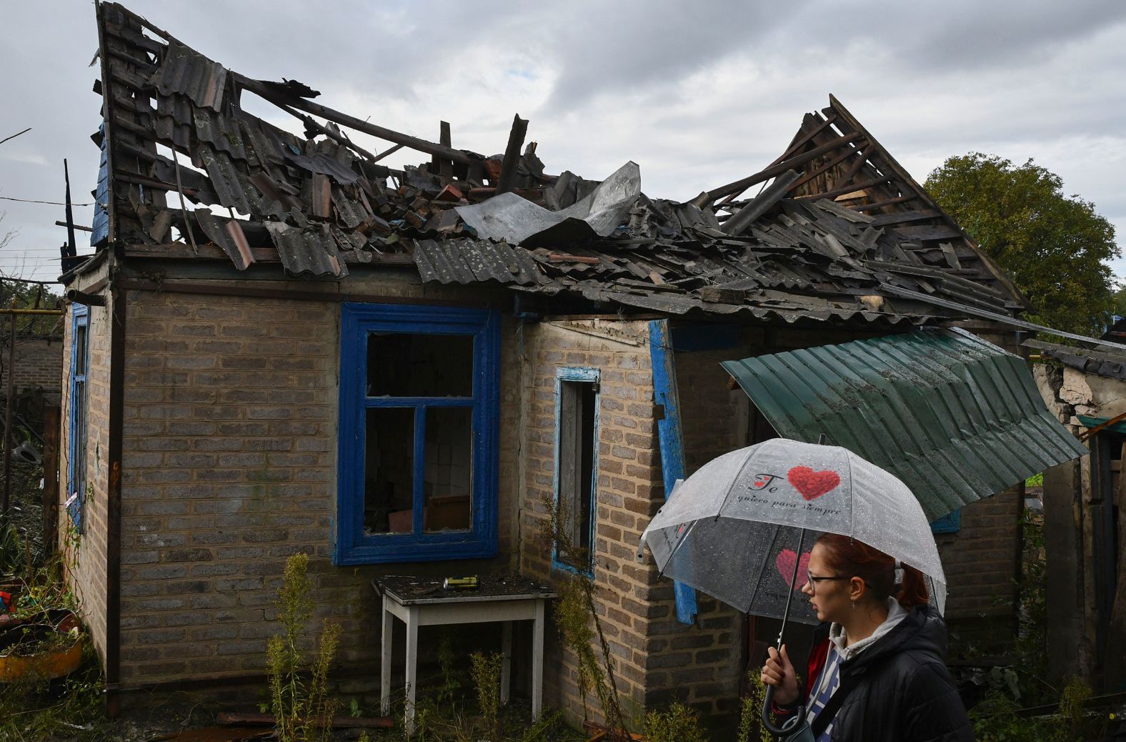 A woman stands next to a residential building that was damaged after an overnight Russian attack in Kramatorsk, Ukraine, on Tuesday, October 4.