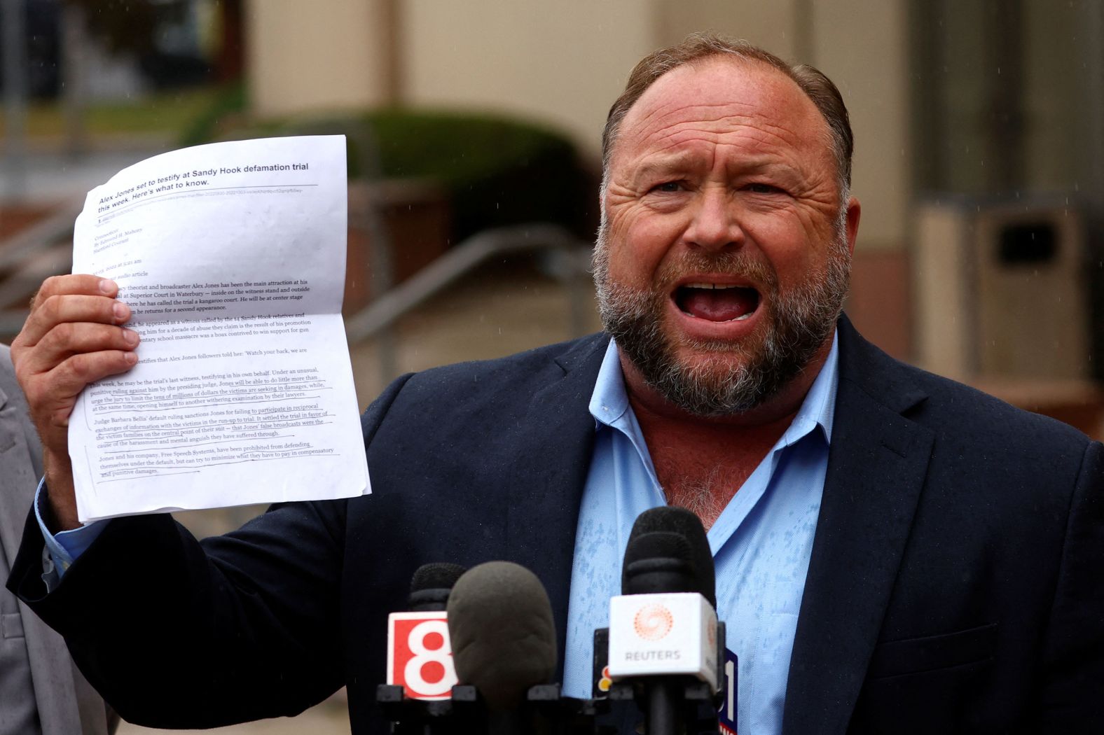 Infowars host and conspiracy theorist Alex Jones speaks to the media after appearing at his Sandy Hook defamation trial in Waterbury, Connecticut, on Tuesday, October 4. The attorneys presented closing arguments in the trial on Thursday.
