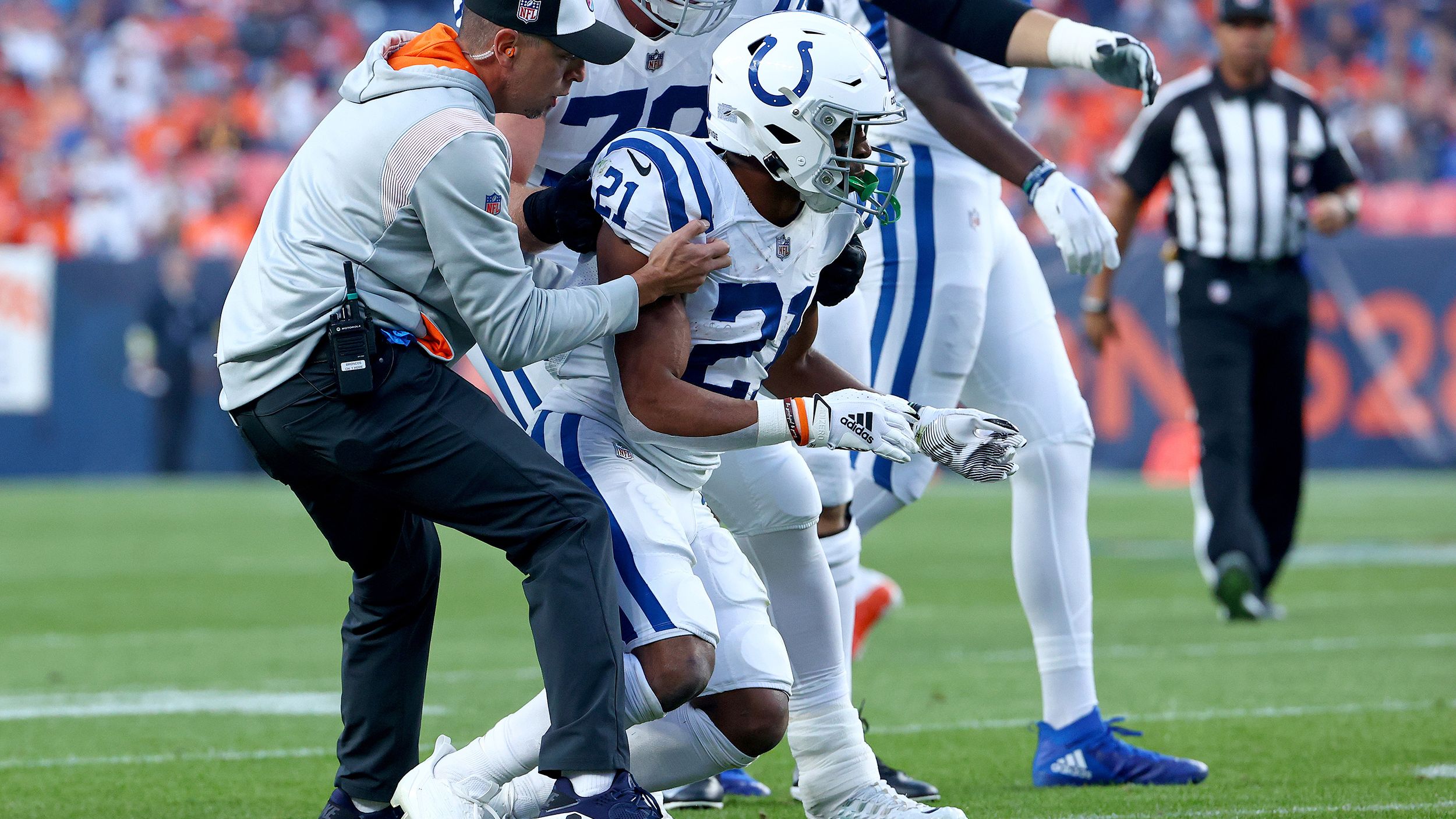 Indianapolis Colts running back Nyheim Hines is helped to his feet after being hit during a game against the Denver Broncos at Empower Field At Mile High on October 6, 2022, in Denver, Colorado. 