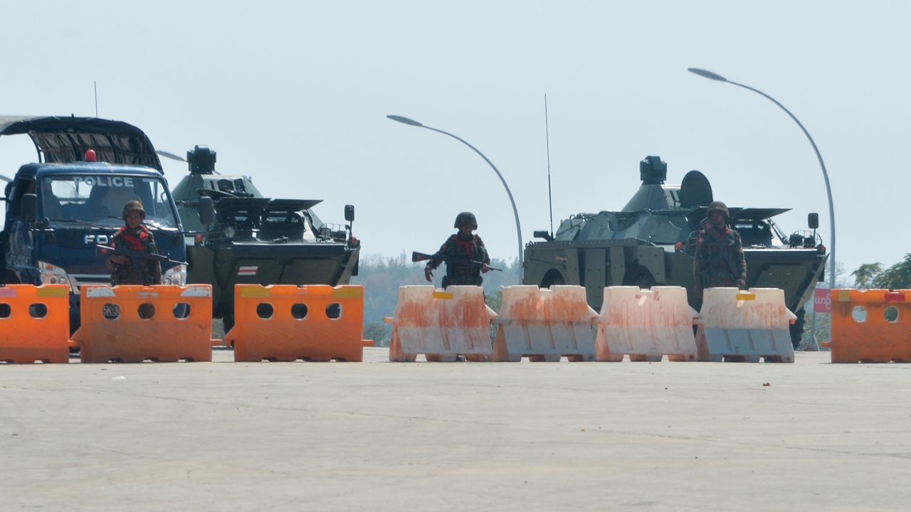 Soldiers stand guard on a blockaded road to Myanmar's parliament in Naypyidaw on February 1, 2021.