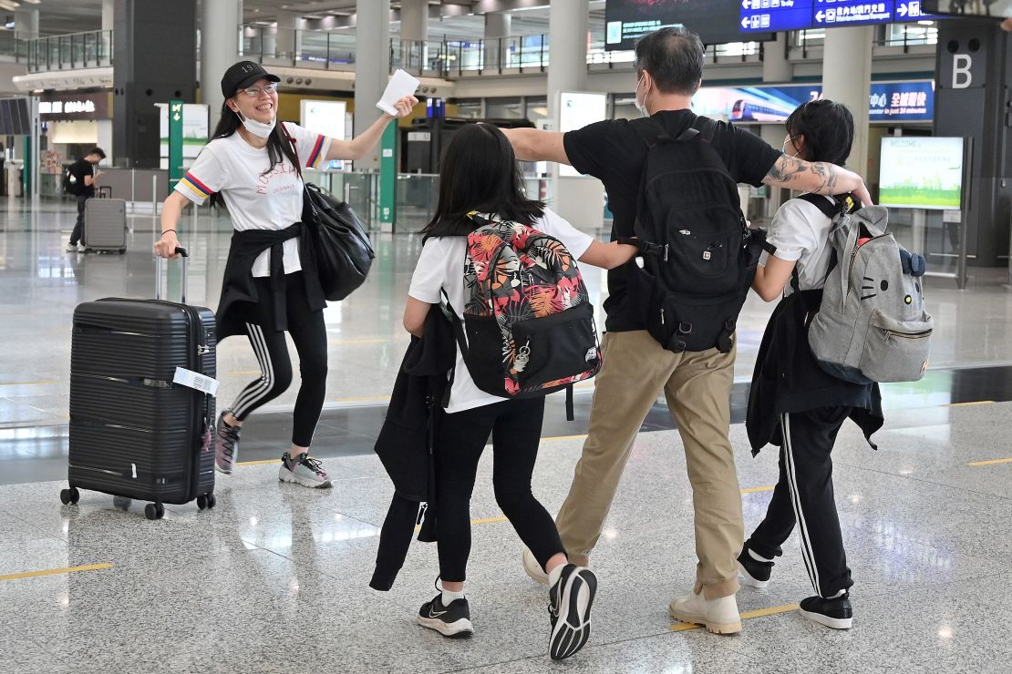 Family members greet each other after arriving at Hong Kong's international airport on September 27, 2022.