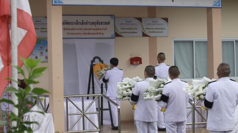 Un oficial tailandés coloca una corona de flores de la familia real para llorar a los asesinados en un centro de cuidado infantil en el norte del país.