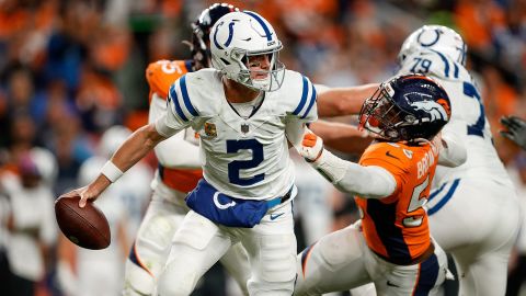 Indianapolis Colts quarterback Matt Ryan scrambles under pressure from Denver Broncos linebacker Baron Browning.