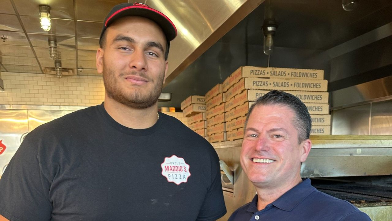Gutierrez (left) poses with restaurant owner Losson Leonard prior to joining the Patriots' practice squad. 