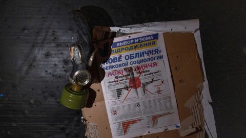 A view of a newspaper and a gas mask hanging on the wall of a room in a police station which a Ukrainian serviceman says was used as a torture chamber by Russian soldiers in the town of Izium in the Kharkiv region, Ukraine, on September 18, 2022.