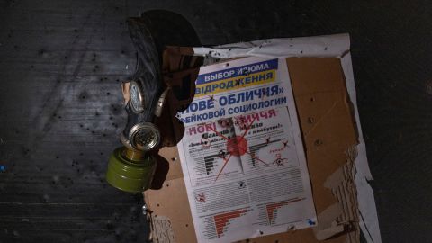 A view of a newspaper and a gas mask hung on a wall at a room in a police station which an Ukrainian serviceman says was used as a torture chamber by Russian soldiers in the town of Izium in Kharkiv region, Ukraine September 18, 2022.