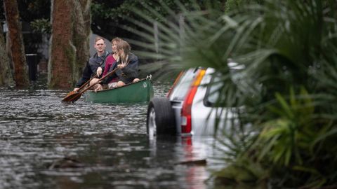 People paddle in a canoe past a submerged car after Hurricane Ian in Orlando, September 29, 2022. 