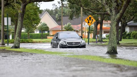 A car drives on a flooded road following the wind and rain from Hurricane Ian in Sanford, Florida, on September 29, 2022.