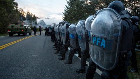 Federal Police line up along a road as they work to remove Mapuche Indigenous people from land they have been occupying for years near Villa Mascardi, Argentina, Tuesday, Oct. 4, 2022.