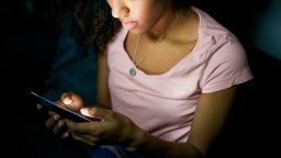 Lonely girl texting on mobile phone late at night